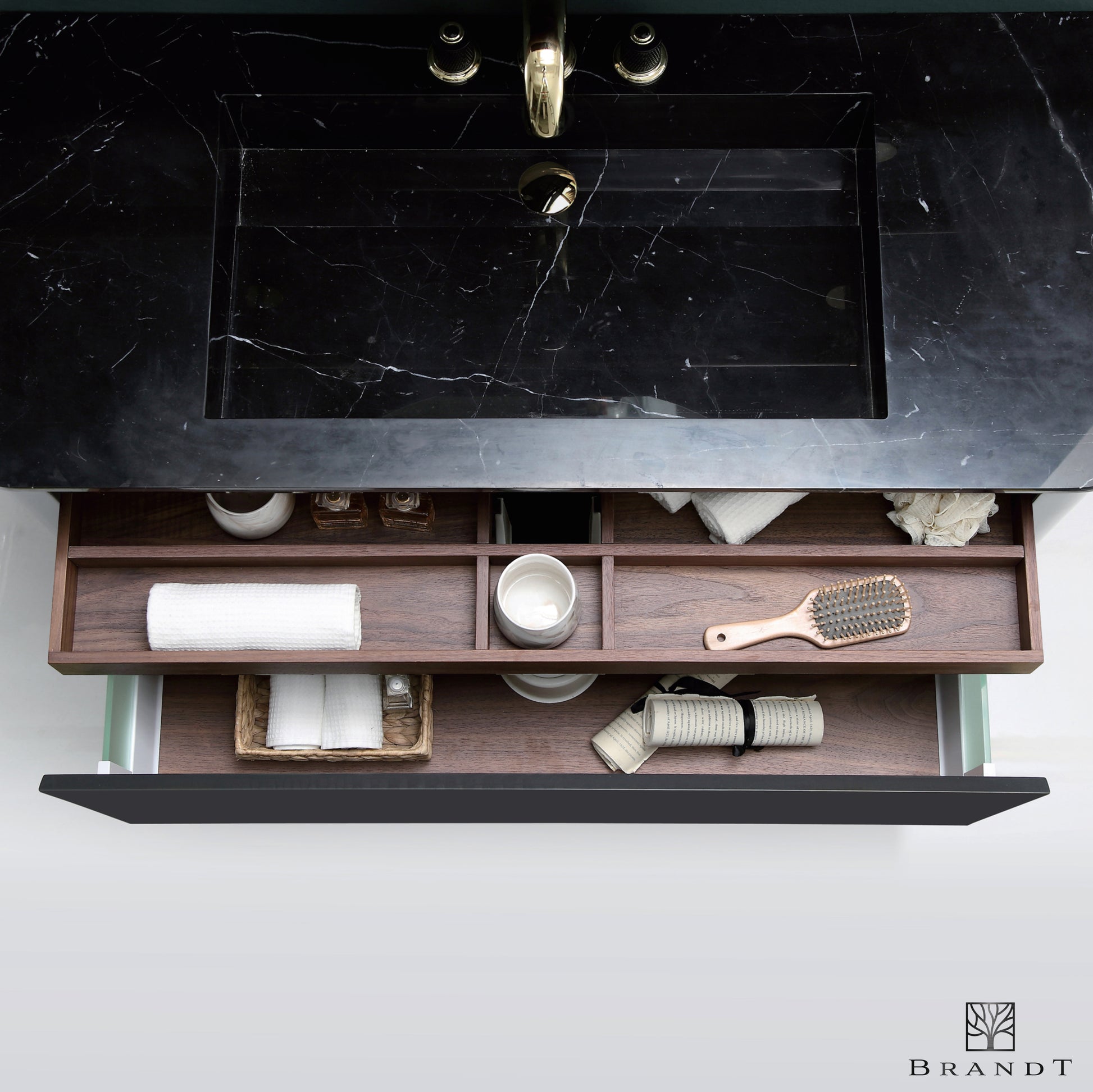 Eksklusivt baderomsmøbel fra Brandt Bad sett ovenfra. Sort polert servant i marmor og utdragne skuffer i valnøtt med praktisk rominndeling