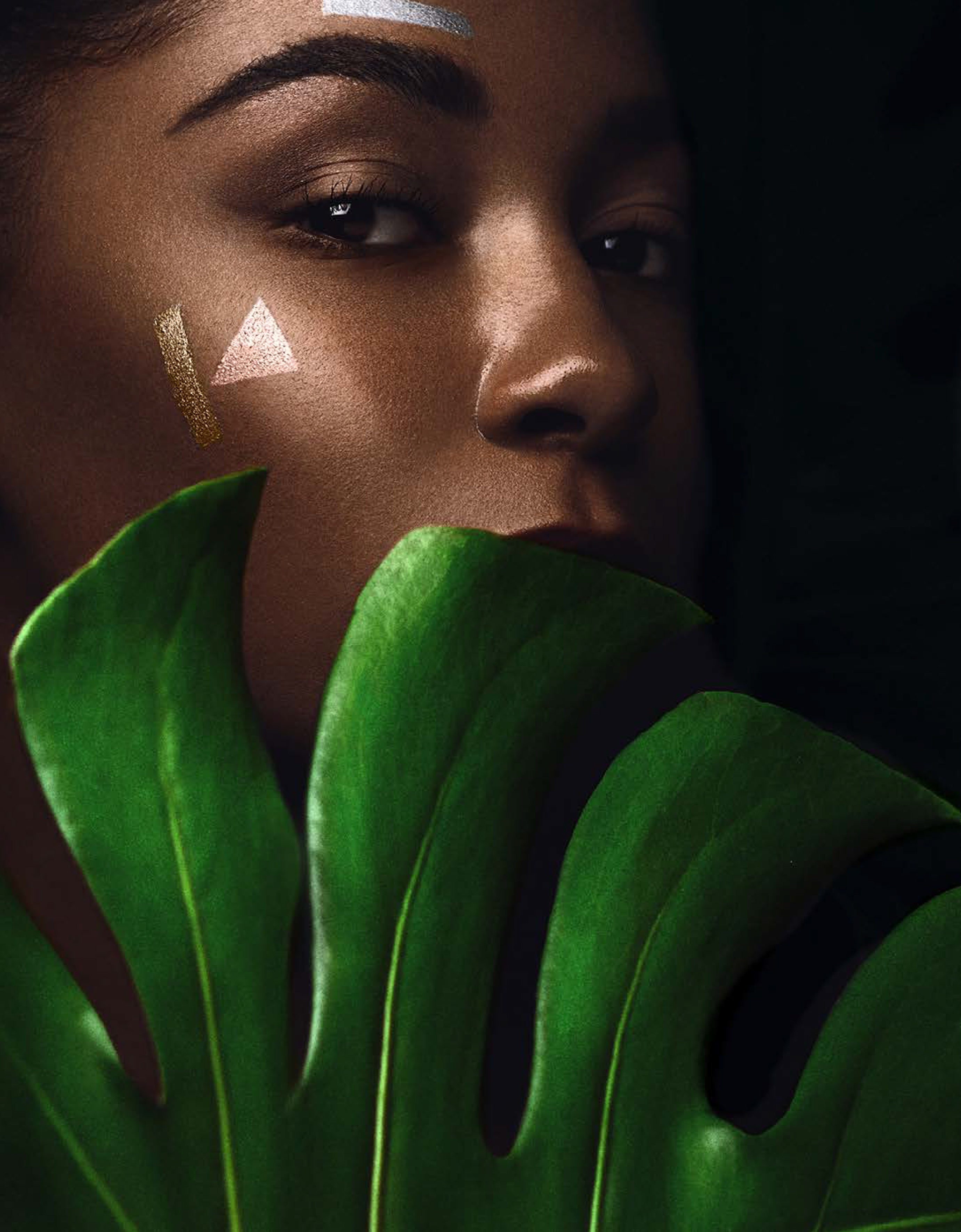 Stemningsbilde til Eterra baderomsmøbel fra Brandt Bad. Ansikt bak grønt palmeblad.