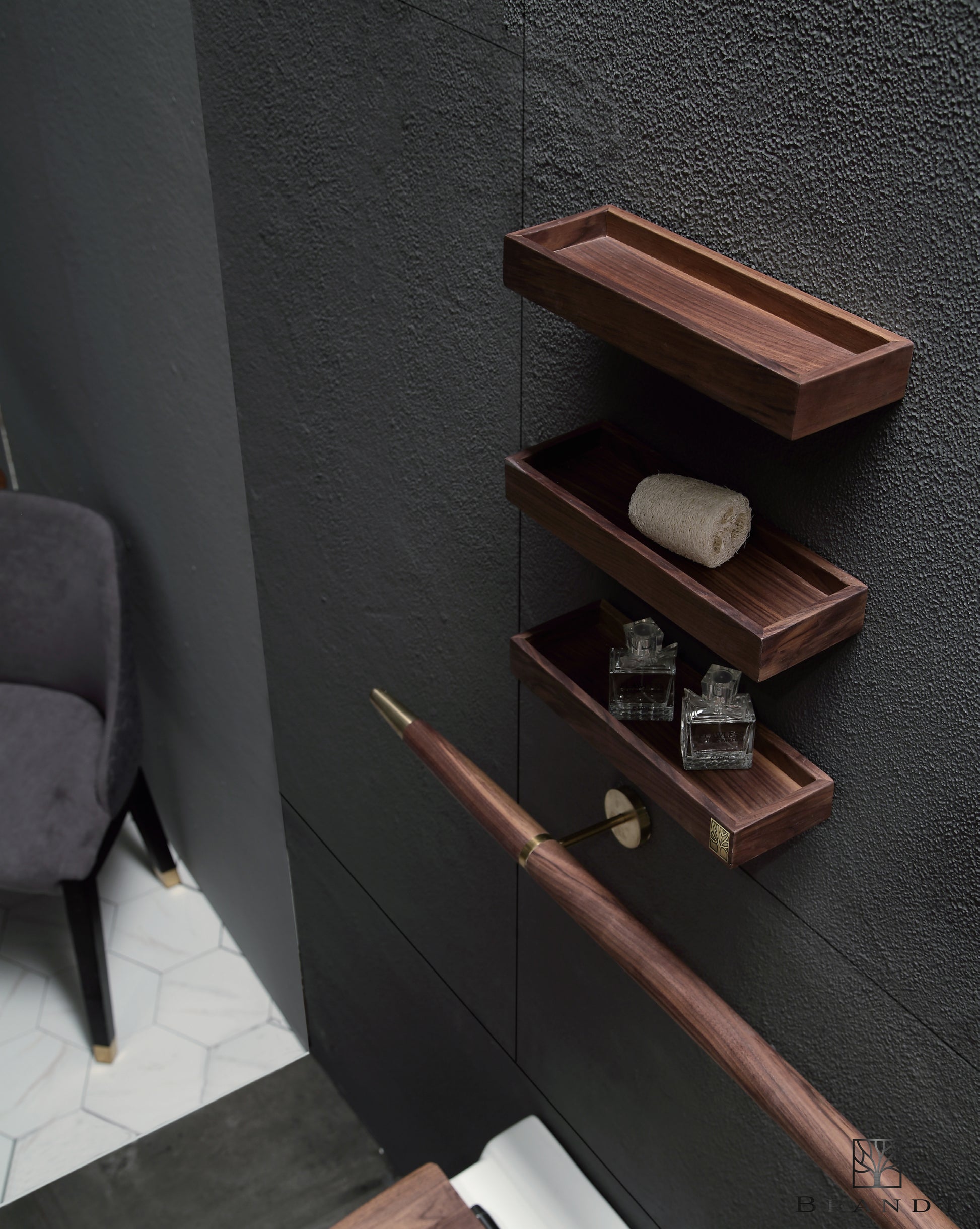 Tilbehør til Eterra baderomsmøbel fra Brandt Bad. Tre små vegghyller i valnøtt og en rund håndklestang i valnøtt med detaljer i messing.