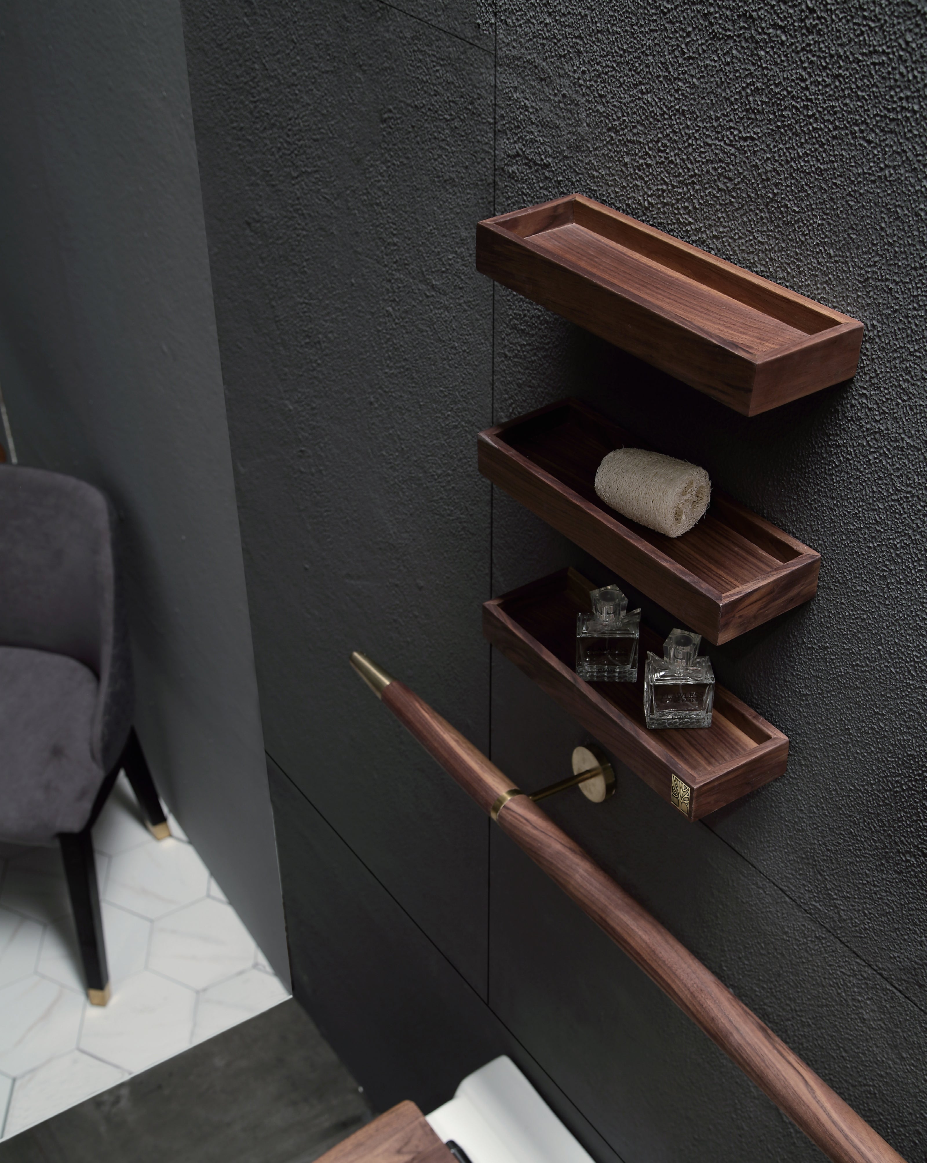 Tilbehør til Eterra baderomsmøbel fra Brandt Bad. Tre små vegghyller i valnøtt og en rund håndklestang i valnøtt med detaljer i messing.