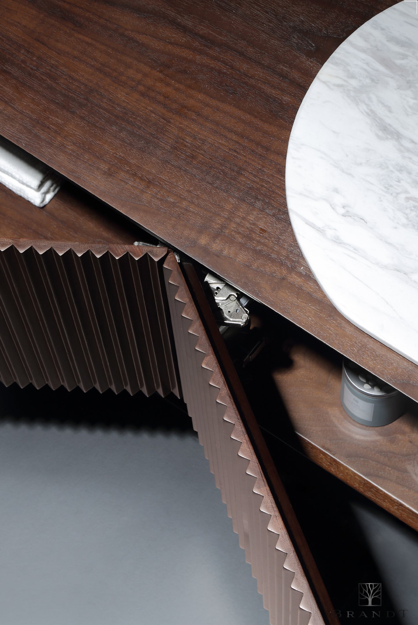 Nærbilde av rillete skapdørfronter på eksklusivt baderomsmøbel i heltre valnøtt med benkeplate i marmor.