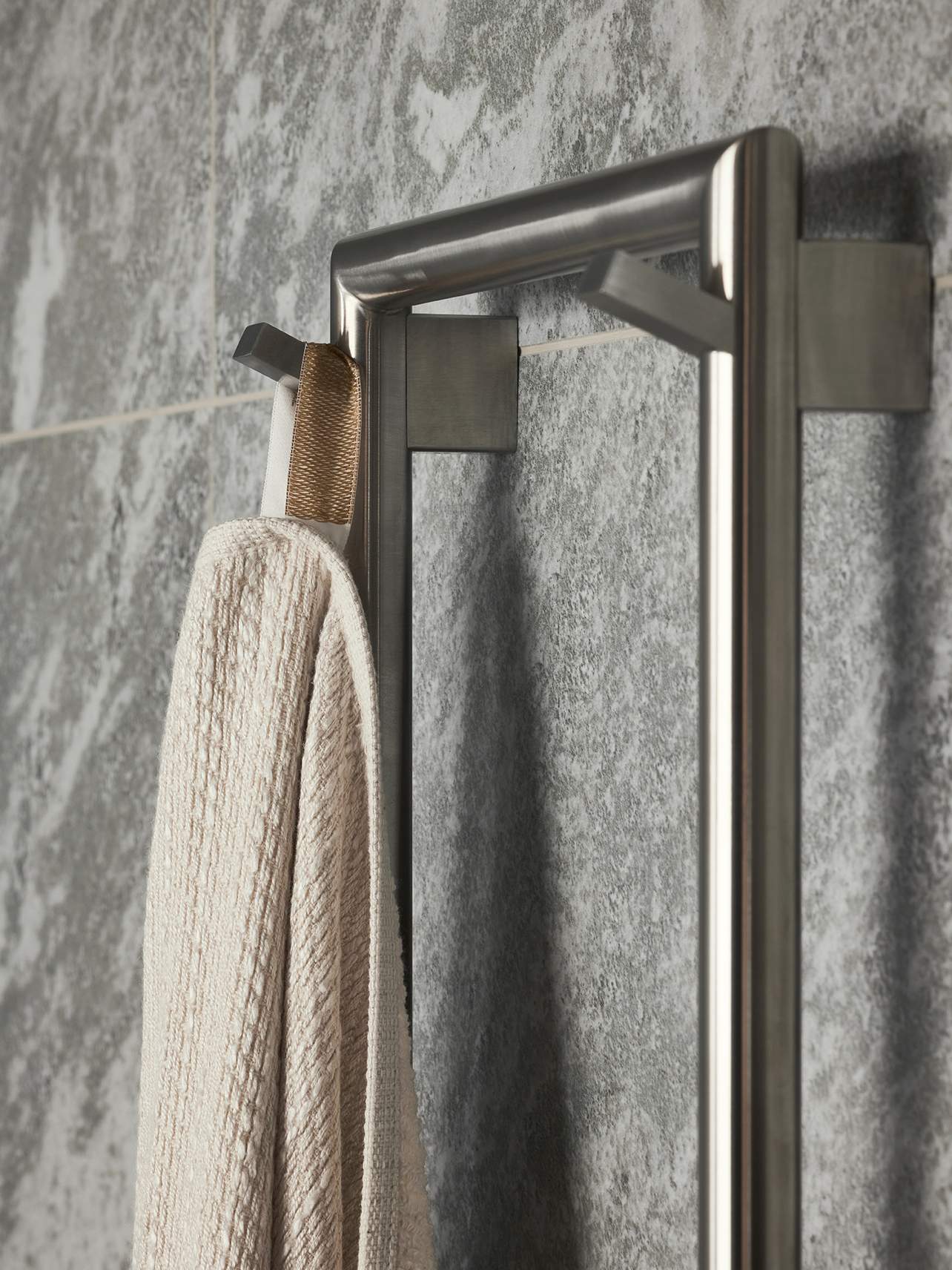 Nærbilde av håndkle som henger fra TW1500-200 Håndkletørker i Brushed Nickel fra tapwell.