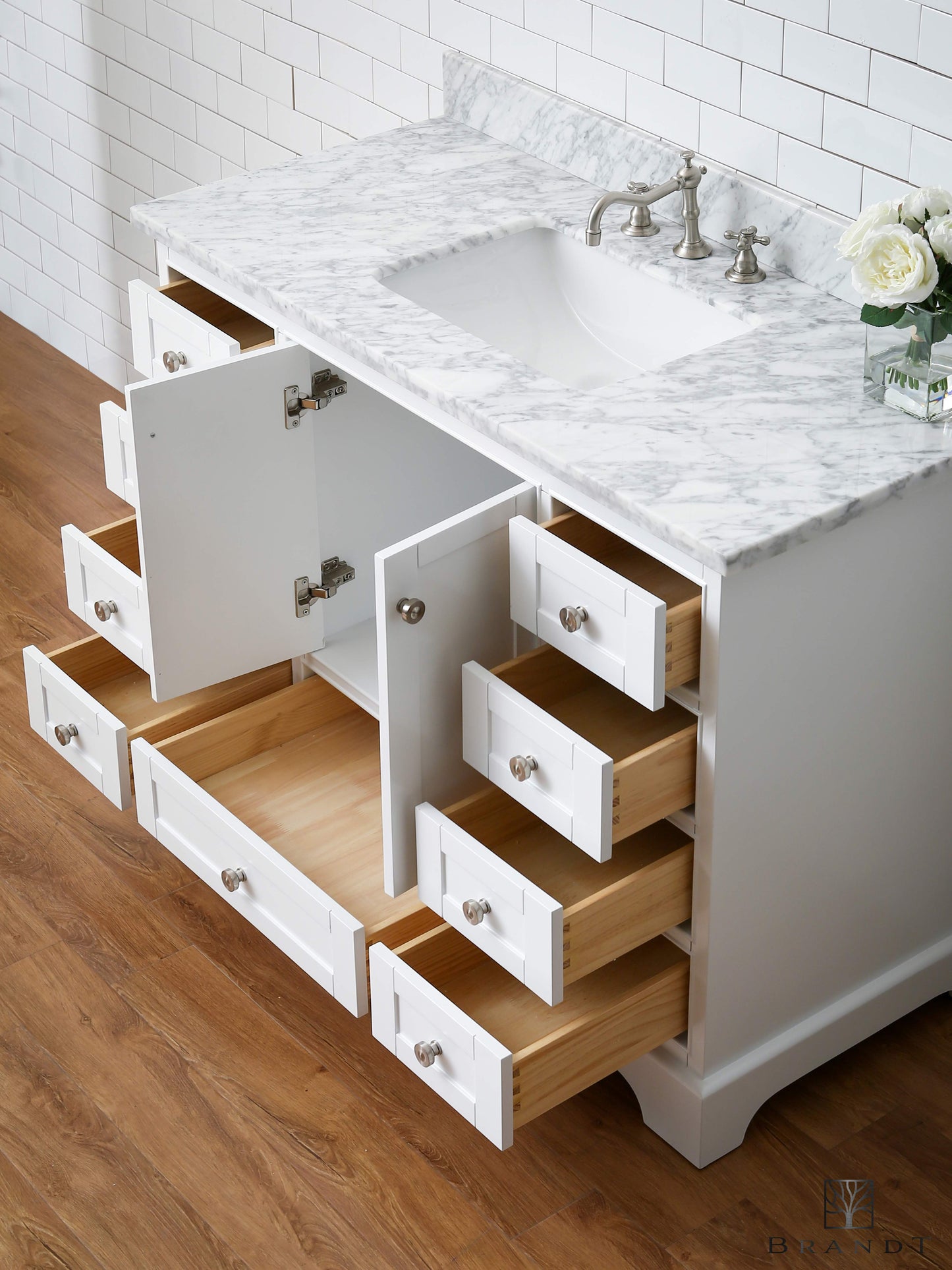 120 cm Bredt Klassisk Hvitt Gulvstående Baderomsmøbel i Kommodestil fra Brandt Bad sett skrått ovenfra med alle skuffer og skapdører åpne. Benkeplate i Ekte Carrara Marmor. Underlimt Vask i Porselen.